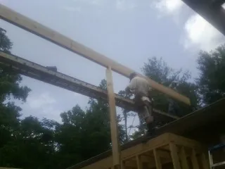 Carpenter setting a ridge beam over a new addition frame — Ice Dam Removal by Roofing Brothers in Wellington